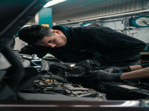 Mécanicien de Prudor Services Pneus au travail sur un moteur